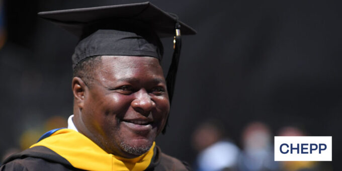 Graduate smiling wearing regalia