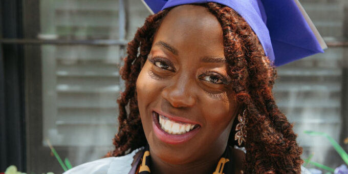 Woman smiling wearing regalia