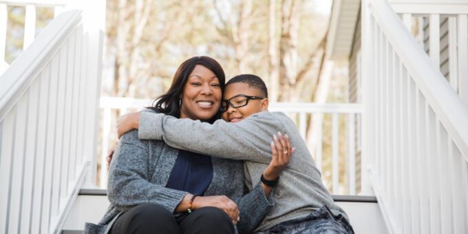 Parent and child on stairs of home