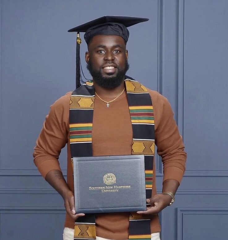 man standing holding SNHU diploma