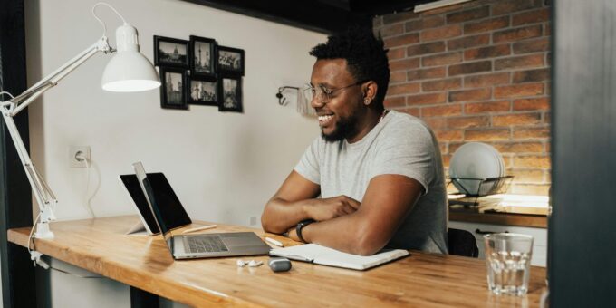 Person sitting at a desk on their laptop, smiling
