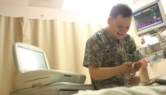 Daniel in military uniform working with medical equipment in a hospital room