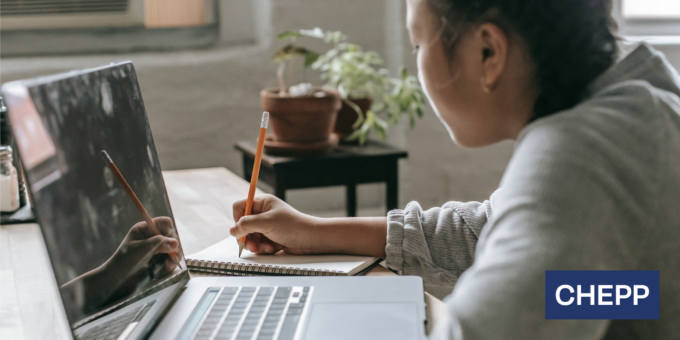 Student sitting at her desk with a laptop in front of her.