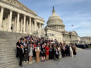 A group of students on a set of stairs in front of a government building.
