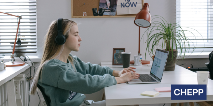 Student wearing headphones while working on a laptop at a desk in a home study space, with the CHEPP logo displayed in the corner.