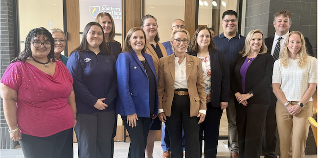 A group of students and professionals gathered in an academic setting.